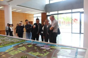 group of people looking at green city plans on a table