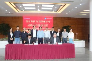 group of people at a red table signing a partnership agreement