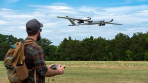 man in a field watching a hydrogen fuel cell aircraft