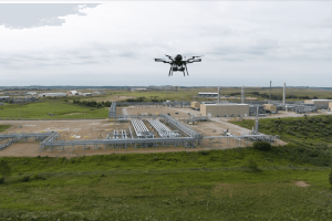 hydrogen fuel cell uav hovering over grass near shell pipelines