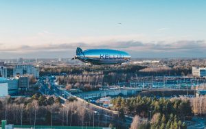 reflective hydrogen fuel cell blimp flying over a city