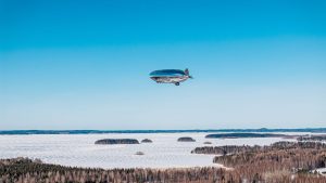 hydrogen fuel cell blimp flying over snowy landscape